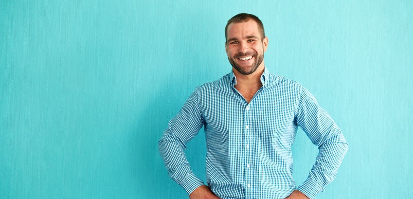 Happy man in front of turquoise wall
