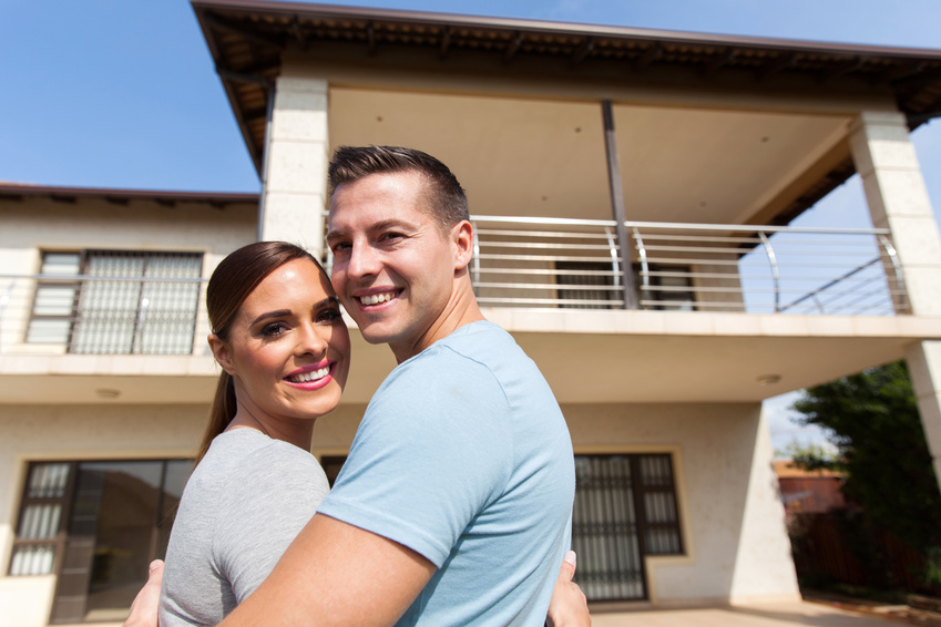 couple looking back in front of their house